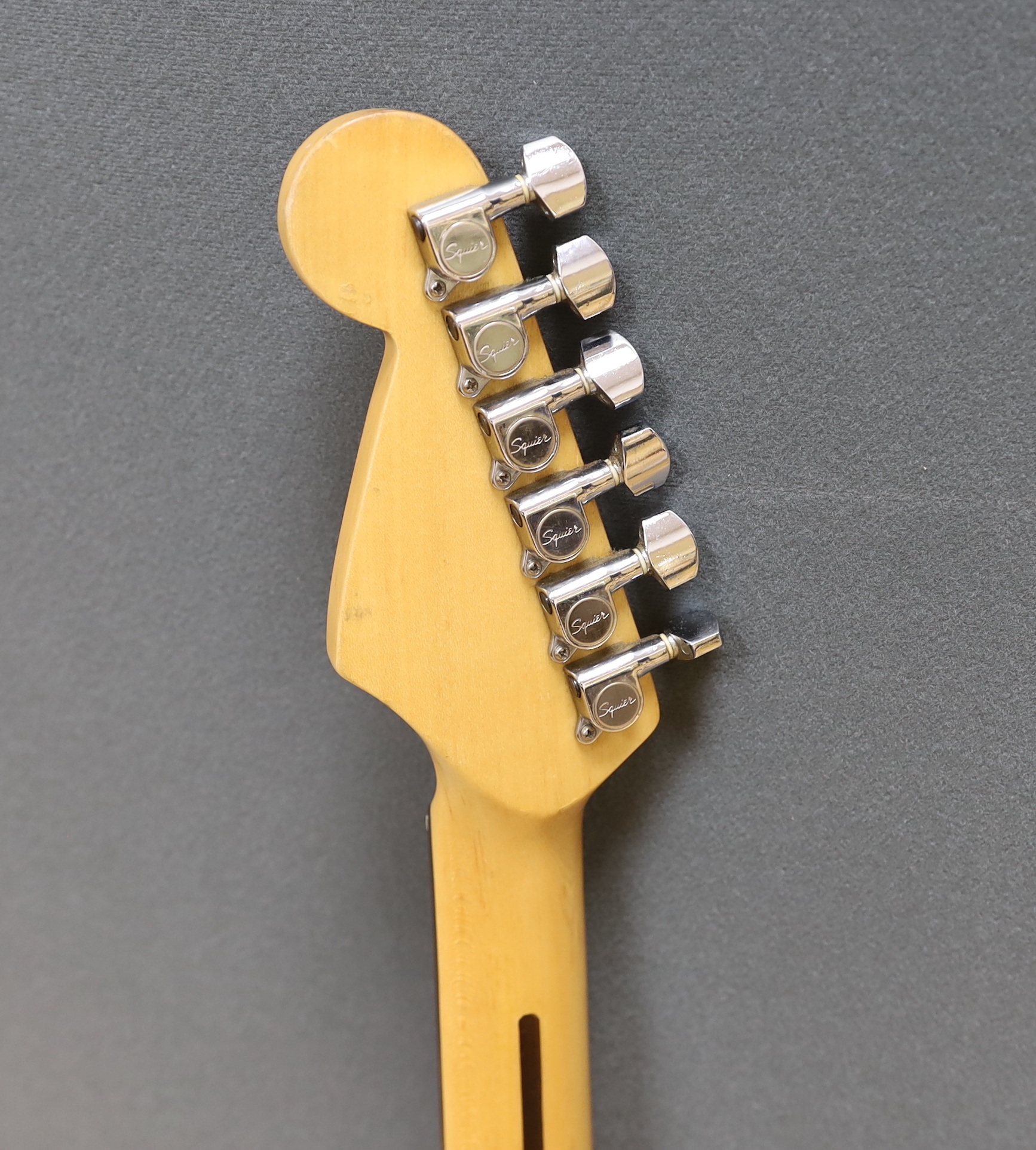 A Squier Strat by Fender electric guitar with rosewood neck and red lacquer body
